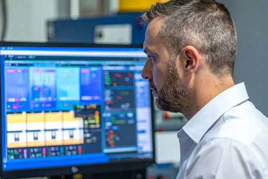 Ein Techniker sitzt vor einem Industrie PC