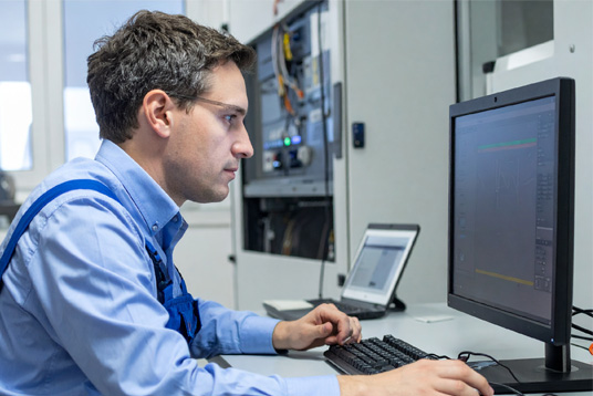 Ein Techniker sitzt vor einem Server und arbeitet